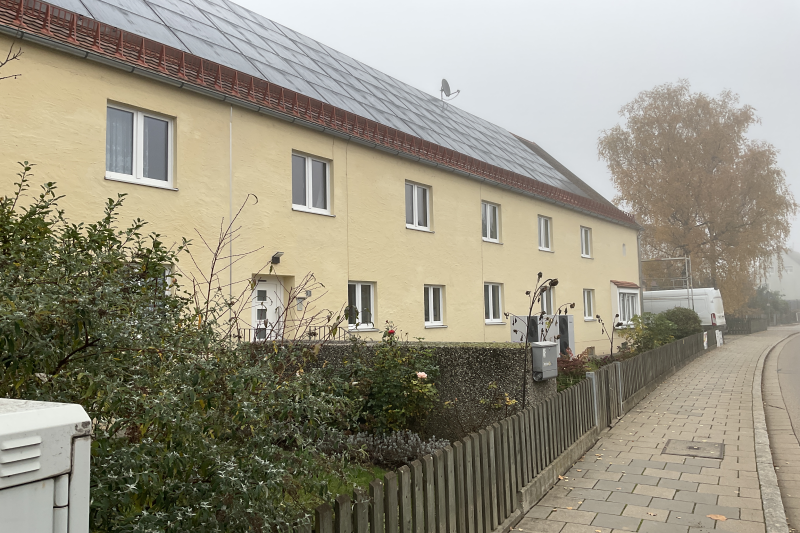 energetische Sanierung eines Mehrfamilienhauses Baujahr ca. 1920 in Regensburg, Stadtteil Burgweinting, Straßenansicht, Abbruch der vorhandenen Kamine, Erneuerung der Gasheizung durch eine Kaskaden-Luft-Wärmepumpe, Photovoltaik-Anlage zur Unterstützung der Heizung- und Stromversorgung des Hauses, Errichtung von Wallboxen für die Mietwohnungen, Dämmungsmaßnahmen der Geschoßdecken